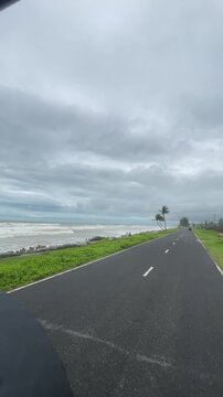 Scenic Marine Drive Road with Leaning Coconut Trees and Stormy Sea in Cox's Bazar, Bangladesh.