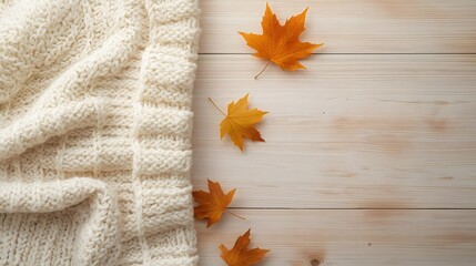 Cozy Comfort of Autumn: a warm and inviting scene, with a soft sweater, gently placed beside vibrant maple leaves, against the backdrop of a textured wooden surface. 