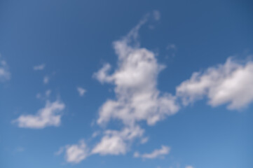 Blurry background with white clouds in a blue sky