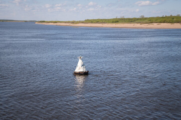 White triangular buoy on the river