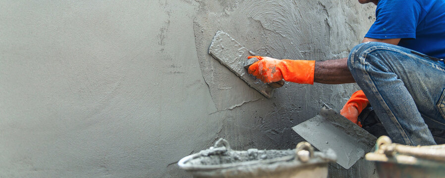 man is laying  brick wall with  trowel