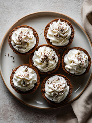 Top View of Mini Chocolate Tarts with Whipped Cream Swirls on a Plate