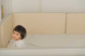 Peaceful Baby Lying on Bed with Soft Natural Light.