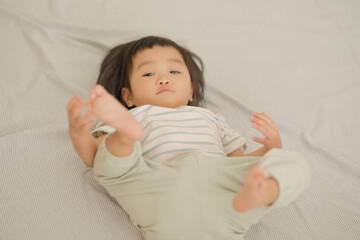 Cute baby lying on bed in soft natural light.