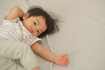 Peaceful Baby Lying on Bed with Soft Natural Light.