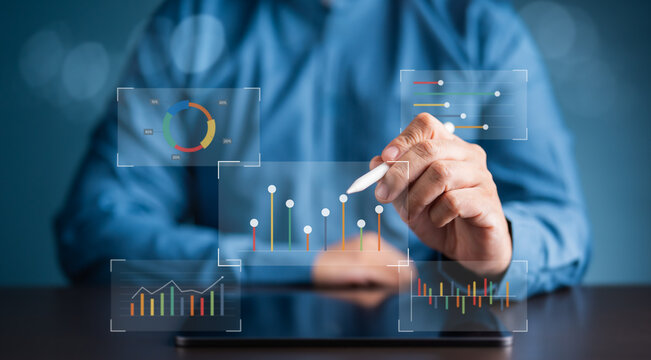 Businessman analyzing financial data using futuristic digital glass effect charts on a tablet. Concept of data visualization, business intelligence, and tech innovation for modern corporate growth. - Powered by Adobe