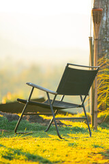 Empty Folding Camping Chair on Green Grass Field During Golden Hour Sunset