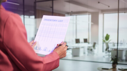 Business professional presenting inventory report in modern office, holding document with charts data analysis concept, management planning corporate workflow financial overview organized records