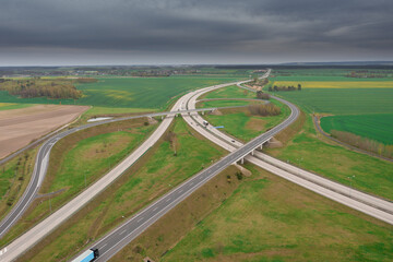Węzeł komunikacyjny widziany z dużej wysokości. Skrzyżowanie dw&oacute;ch autostrad ze zjazdami, wjazdami w formie serpentyn. Zdjęcie z drona.