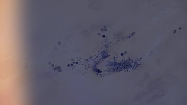 Satellite view of Tazirbu Oasis, Libya, sunrise time lapse aerial flyover of desert agricultural patterns based on NASA imagery