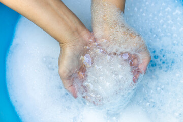 Fototapeta premium Hands Holding Soap Bubbles in Clean Water, Close-up, Wash hands hygiene, cleanliness, handwashing routine, and disease prevention through proper sanitation