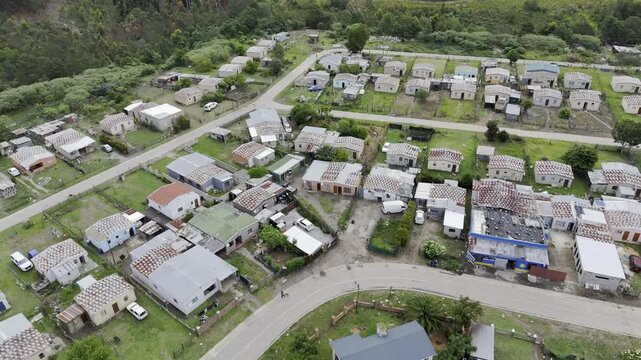 Drone spirals down over township on a partially sunny day in Stormsrivier, Eastern Cape, South Africa