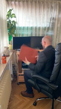 Ejecutivo de negocios trabajando en oficina con carpeta archivador y documentos sentado en silla de despacho