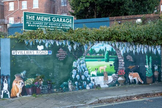 Southsea England - January 4 2026: mural at mews garage Southsea looking though a garden to dogs in a park