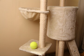 Cat tree with a tennis ball and relaxing spot for pets displayed inside a house