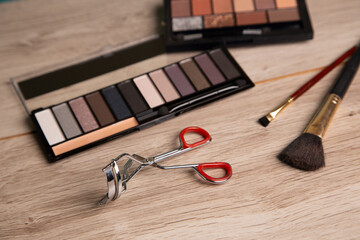 Makeup tools and items arranged on a wooden surface for a beauty routine at home in the afternoon