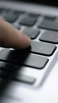 Pressing the Enter key on a keyboard. Close-up. Vertical video.
