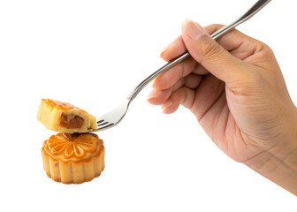 Hand holding fork with mooncake piece above another mooncake on white background