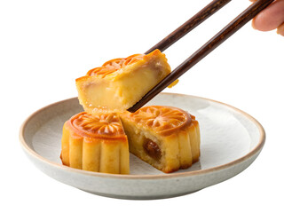Delicious traditional mooncakes being picked up with chopsticks from a ceramic plate