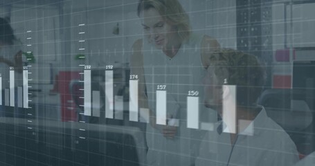 Leaning mid-adult woman presenting data in open-plan office, wearing white blouse, glass bar chart