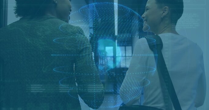 Walking coworkers in dark top, light blouse down office, showing digital globe and shoulder bag - Powered by Adobe