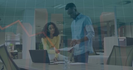 Leaning woman yellow top and man blue shirt reviewing papers, laptop at meeting table chart overlay