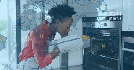 Removing aproned woman holding loaf on tray with oven mitts at oven in kitchen, holographic map