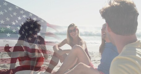 Naklejka premium Sitting five adults in swimwear and sunglasses chatting on beach at shore, faded US flag overlay