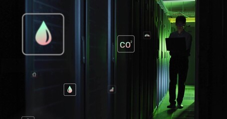 Monitoring Korean tech in long sleeves holding laptop in server aisle, hologram icons, copy space