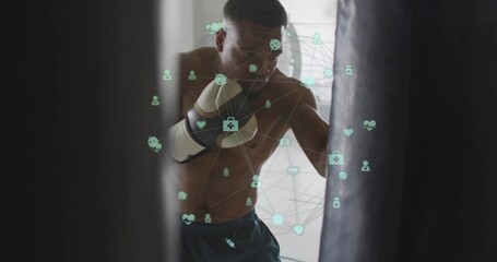 Punching shirtless boxer training in narrow gym with heavy bag, gloves and shorts, digital overlay