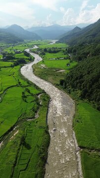 Aerial Drone View of Nuwakot Valley with River Dividing Paddy Fields and Surrounding Mountains