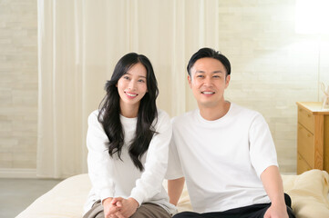 夜の寝室で笑顔で会話をする日本人男女