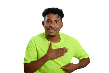 A smiling young man in a neon green t-shirt gestures, beating his chest, against 
