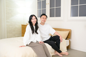 夜の寝室で笑顔で会話をする日本人男女