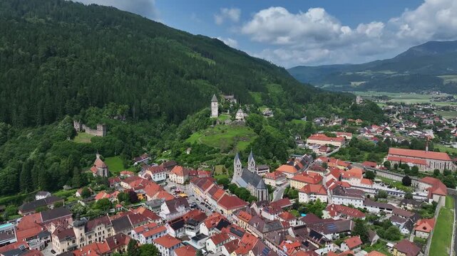 Summer drone footage showing medieval Friesach, old fortified walls, rooftops, towers, hills, serene atmosphere, warm daylight, gentle cinematic motion