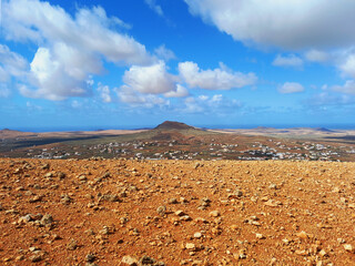 Fototapeta premium volcanic landscape. Desert area with stones, rocks and sandstone and silhouette of volcano slopes on the horizon. Landscapes and extreme nature.