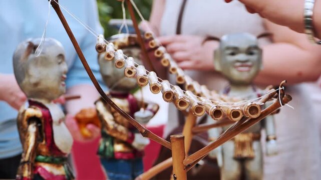 Traditional vietnamese water puppets playing bamboo xylophone during festival in Moscow