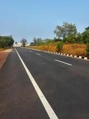 Close-up photograph of an Indian road surface captured in natural daylight. The image highlights road texture, asphalt details, lane markings, wear patterns, and surface conditions commonly seen on ro