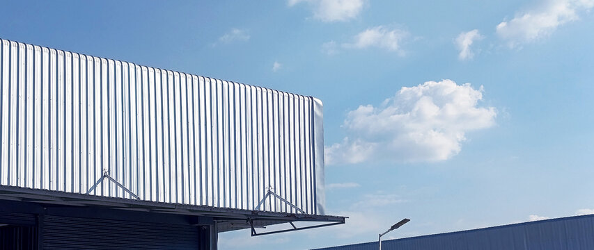 Metal sheet roof curve on blue sky. Modern construction, Metal ribbed arch span roof covering, Large building roof. not ai