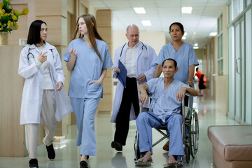 Obraz premium a group of medical professionals walking together in a hospital corridor. Two doctors are discussing something while walking, one holding a clipboard. A nurse is pushing a patient in a wheelchair,