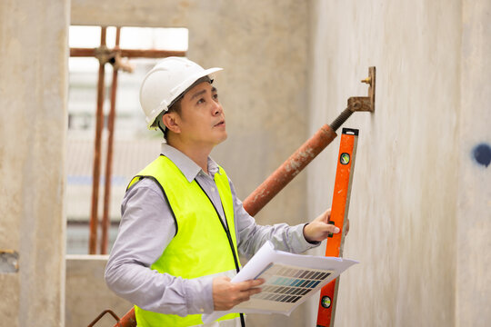 measurement horizontal deviation of construction. Balance Bubble level ruler, Tools equipment building and engineering. Civil engineer Asian man in safety hard hat helmet working at construction site