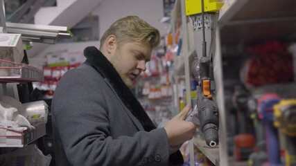 Professional worker inspecting shelves in hardware shop