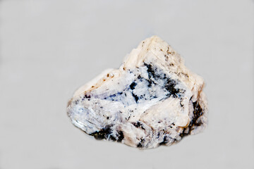 Anhydride with black spots on a light background. Gems, mineralogy, jewelry.