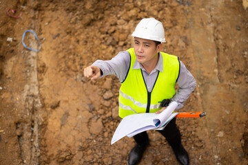 Top view above, inspection plan, Architect or contractor with blueprint working on house building under construction. Professional Architects Engineer construction site. Civil Engineering