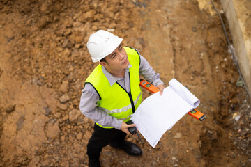 Top view above, inspection plan, Architect or contractor with blueprint working on house building under construction. Professional Architects Engineer construction site. Civil Engineering