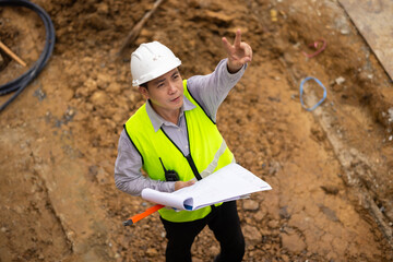 Top view above, inspection plan, Architect or contractor with blueprint working on house building under construction. Professional Architects Engineer construction site. Civil Engineering