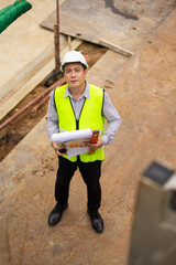 Top view above, inspection plan, Architect or contractor with blueprint working on house building under construction. Professional Architects Engineer construction site. Civil Engineering