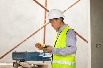 Use construction tools and open tool box. Balance Bubble level ruler, Tools equipment building and engineering. Civil engineer Asian man in safety hard hat helmet working at construction site