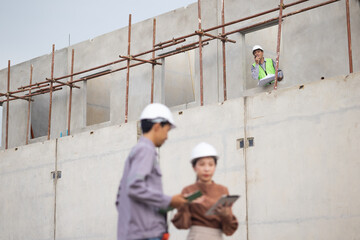 walkie talkie, Asian Man working, Architect or contractor working on house building under construction. Professional Architects Engineer construction site. Civil Engineering in safety harthat helmet