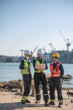 Professional engineering working at shipyard, Professional logistics monitoring cargo operations at industrial shipyard.